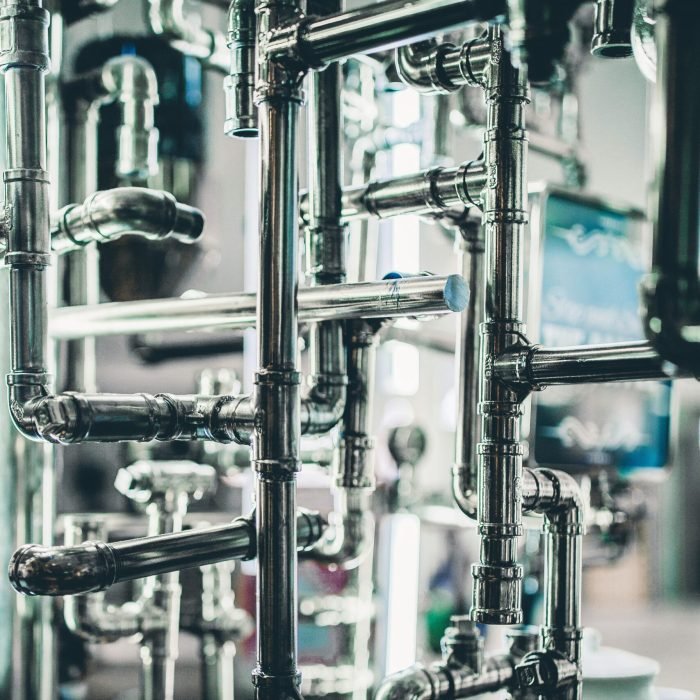 Close-up of complex stainless steel pipes in an industrial setting, showcasing modern engineering.